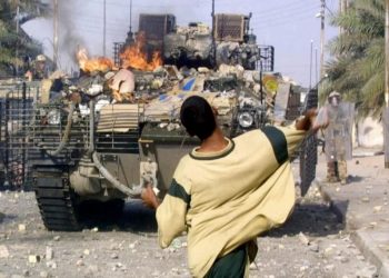 عراقي يرشق جنود بريطانيين بالحجارة خلال اشتباكات في مدينة البصرة جنوبي العراق. 19 سبتمبر 2005.صورة.AFP